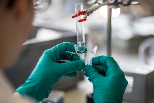 Scientist working with green gloves in a lab